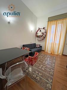 a living room with a glass table and a couch at Suite Nana by Apulia Accommodation in Bari