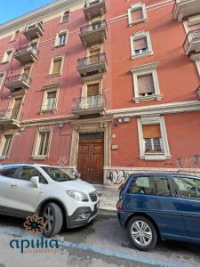 two cars parked in front of a building at Suite Nana by Apulia Accommodation in Bari