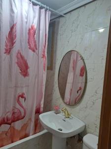 a bathroom with a sink and a pink shower curtain at Piso amplio y acogedor in Madrid