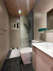 y baño con aseo, lavabo y ducha. en Lai Yi Ke Homestay, en Baisha