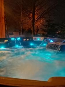 una piscina con luces azules por la noche en LendHouse - SPA pod Gwiazdami, en Sąpów