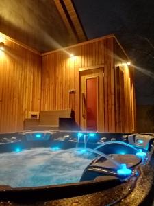 a large hot tub with blue lights in a room at LendHouse - SPA pod Gwiazdami in Sąpów