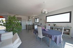 a living room with a table and chairs and a kitchen at La Moulinière in Pennautier