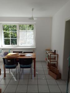 a kitchen with a table and chairs and two windows at Wohnung im Park in Thulendorf