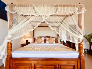 a bedroom with a canopy bed with white curtains at Heaven's Edge By EHI in Ella