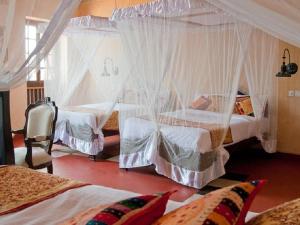a bedroom with two beds with mosquito nets at Mizingani Seafront Hotel in Zanzibar City