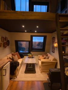 ein Wohnzimmer mit 2 Sofas und einem Tisch in der Unterkunft Mikrohyttene Moen Ranch in Kragerø
