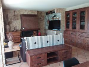 cocina con armarios de madera, TV y sofá en Magnifique villa piscine Propriano, en Olmeto