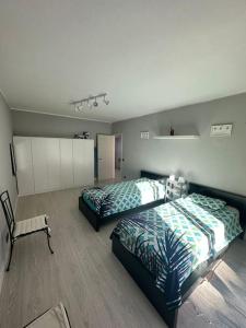 una camera con due letti e una sedia di Apartamento T2 com terraço a 100 metros da praia a Carvoeiro
