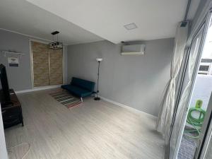 un soggiorno con divano blu e finestra di Apartamento T2 com terraço a 100 metros da praia a Carvoeiro