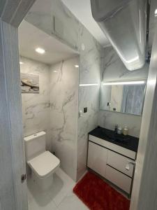 bagno bianco con servizi igienici e lavandino di Apartamento T2 com terraço a 100 metros da praia a Carvoeiro