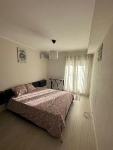 una camera con un grande letto e una finestra di Apartamento T2 com terraço a 100 metros da praia a Carvoeiro