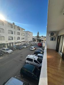 vista su una strada con auto parcheggiate in un parcheggio di Apartamento T2 com terraço a 100 metros da praia a Carvoeiro