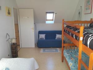 a bedroom with a bunk bed and a blue couch at L'Ecume de Mer in Wissant