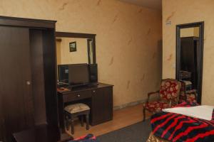 فندق بيت العروبة في الرياض: غرفة نوم مع تلفزيون وسرير وكرسي