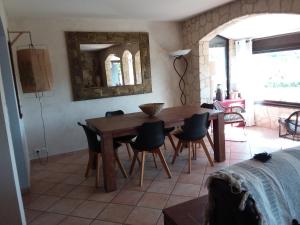 a dining room with a wooden table and chairs at Magnifique villa piscine Propriano in Olmeto