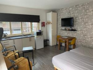 ein Schlafzimmer mit einem Bett und eine Küche mit einem Tisch in der Unterkunft Appartement Villa Eva Rosa in Wijk aan Zee