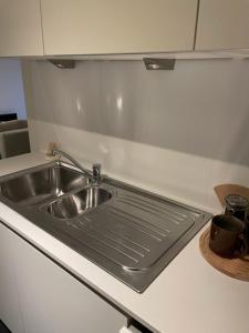 un fregadero de acero inoxidable en una cocina blanca en White Princess - Lehouck, en Koksijde