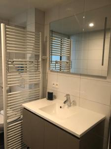 a white bathroom with a sink and a mirror at White Princess - Lehouck in Koksijde