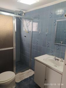 ein Badezimmer mit Dusche, Toilette und Waschbecken in der Unterkunft Apto a 25 metros areia PITANGUEIRAS Vista mar 4 quartos 3 banheiros 1 vaga carro Serviço de praia in Guarujá