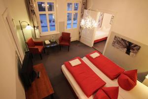 Hotel Garni Zur Linde في هيتسآكر: غرفة نوم بسرير ومخدات حمراء