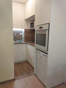 a kitchen with white cabinets and a stove top oven at Augusta Apartment in Stara Zagora
