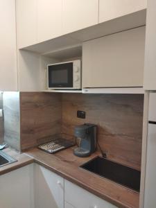 a kitchen with a microwave and a sink at Augusta Apartment in Stara Zagora