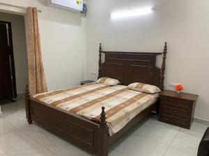 a bedroom with a large bed and a night stand at Staywell360 in Chandīgarh