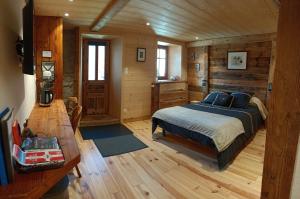 a bedroom with a bed in a wooden cabin at Atelier des Sapins Blancs (chambre double) in Vacheresse