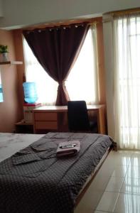 mando a distancia sentado en la parte superior de una cama con ventana en MARGONDA RESIDENCE 3 en Kemirimuka Dua