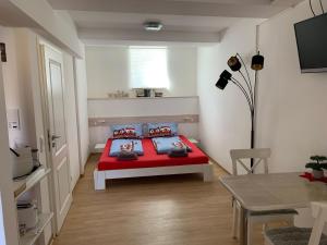 a bedroom with a red bed and a table at Ferienwohnung "Alte Mühle" in Jena