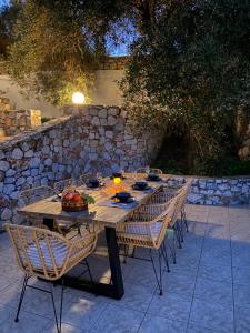 a wooden table with chairs and food on it at Villa Armonia in Crete, quiet with sea view & pool in Xirostérnion