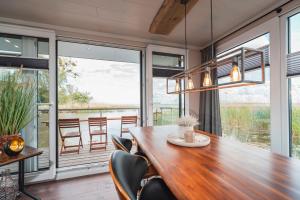 a dining room with a large wooden table and chairs at Hafenresort Karnin _ Hausboot Silv in Karnin