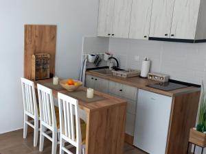 una cucina con mobili bianchi, tavolo e sedie di Studio Lola Jezero a Divčibare