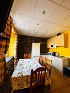 a kitchen with a table with chairs and a refrigerator at La Milana in La Robla +23 photos