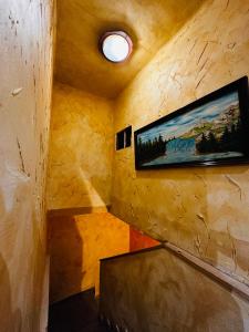 a room with a tv on a wall with a painting at La Milana in La Robla
