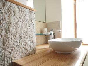 uma casa de banho com um grande lavatório branco num piso de madeira em Alloggio turistico Corte Grisi em Badia Calavena