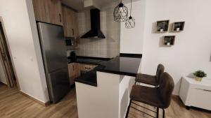 uma cozinha com um balcão preto e um frigorífico em El Rincón del Bito em Cazorla