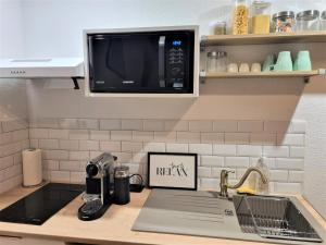 a kitchen counter with a sink and a microwave at Le Chalet in Charbonnières-les-Bains +10 photos
