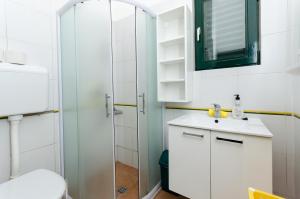 a bathroom with a toilet and a sink and a shower at Gonar 300 Rab in Supetarska Draga