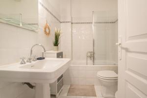 bagno bianco con lavandino e servizi igienici di Grand 3 Pièces Central et Calme a Mentone