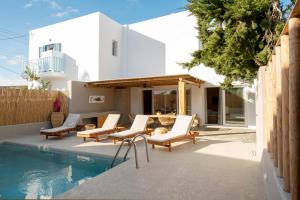 a patio with lounge chairs and a swimming pool at Kostantakis Pool house in Pollonia