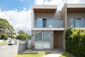 uma casa de tijolos com uma fachada de vidro em Spacious 4BR Villa with Office l Modern & Convenient em Sydney