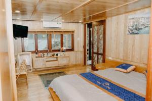 a bedroom with a bed and a desk in it at Lan Ha Floating Homestay in Cat Ba