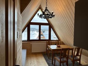 Un comedor con una mesa y una lámpara de araña. en Apartament Krystynka Giewont, en Poronin