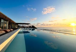 a swimming pool with a view of the ocean at Kumba Lodge in Praia do Tofo