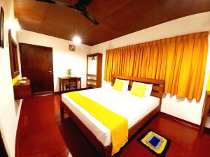 1 dormitorio con 1 cama grande con sábanas blancas y amarillas en Coco Garden Villas 1, en Hikkaduwa