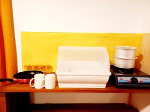 a white toaster sitting on top of a wooden shelf at Coco Garden Villas 1 in Hikkaduwa