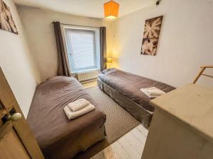 ブイヨンにあるLa Maison Hôte, gîte de charme en bord de Semoisのベッド2台と窓が備わる客室です。