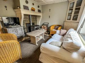 a living room with a couch and a fireplace at La Maison Hôte, gîte de charme en bord de Semois in Bouillon